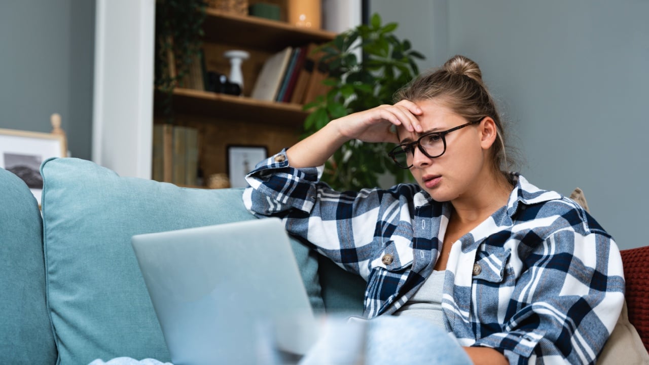 Confused young woman looking on laptop at home feeling bewildered by no connection, reading online news in internet, annoyed teen girl angry with stuck computer problem, scam spam email, system error