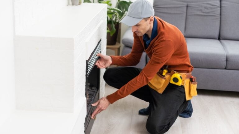 Professional technician installing electric fireplace in room.