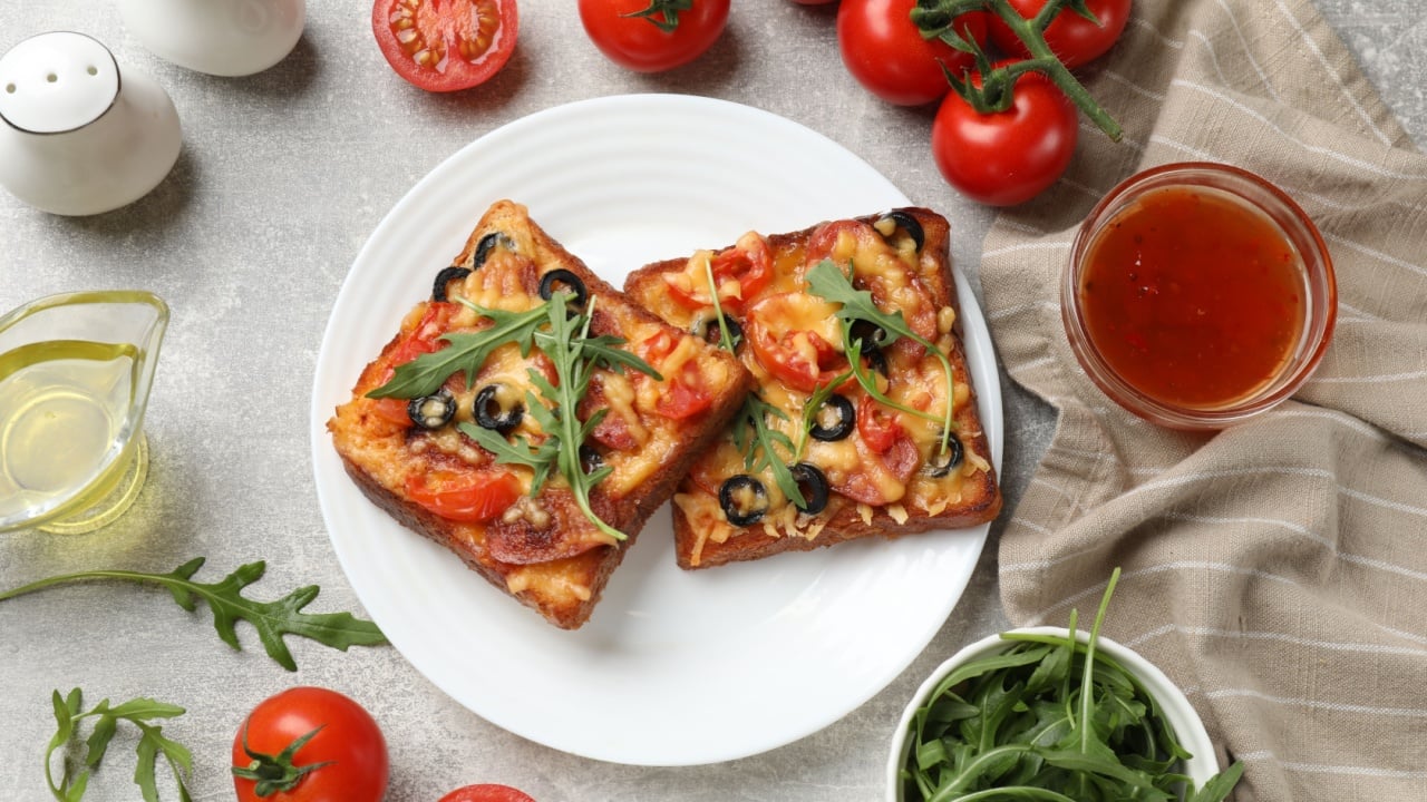 Tasty pizza toast and ingredients on grey table, flat lay