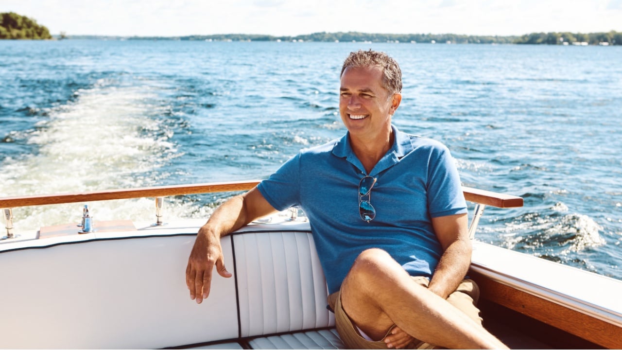 Mature man, yacht and travel with thinking for retirement, smile on water cruise for future plan. Male person, boat or thoughtful for pension goal on summer vacation, happy trip on ocean in Bali