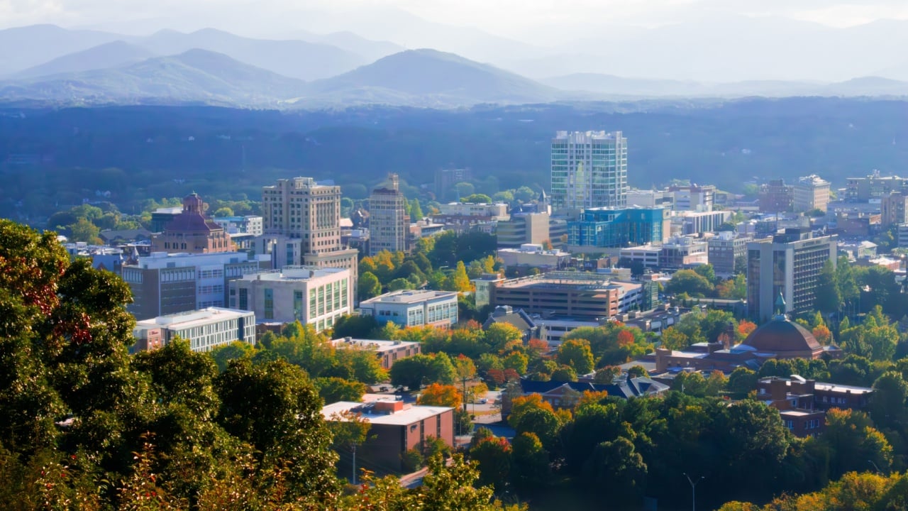 View of Western North Carolina's City of Asheville's skyline with the Blue Ridge Mountains in the background, Buncombe County, fall of 2024, close to Tennessee, South Carolina, and Virginia.