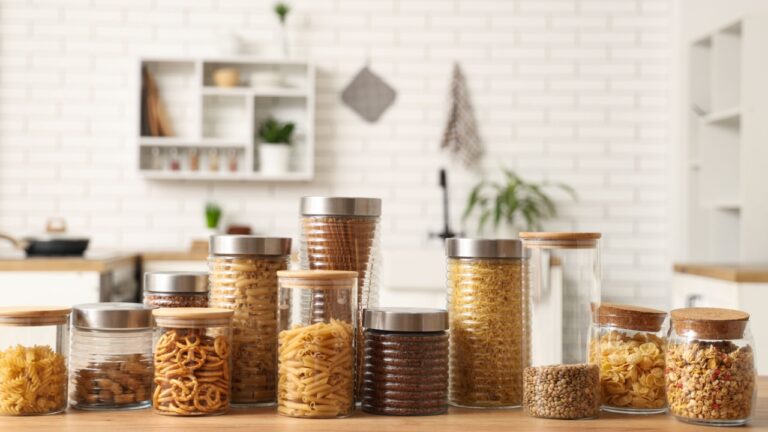 Many glass jars with different products on table in kitchen