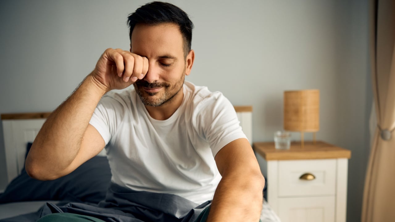 Sleepy man struggling to wake up in the morning. Copy space.