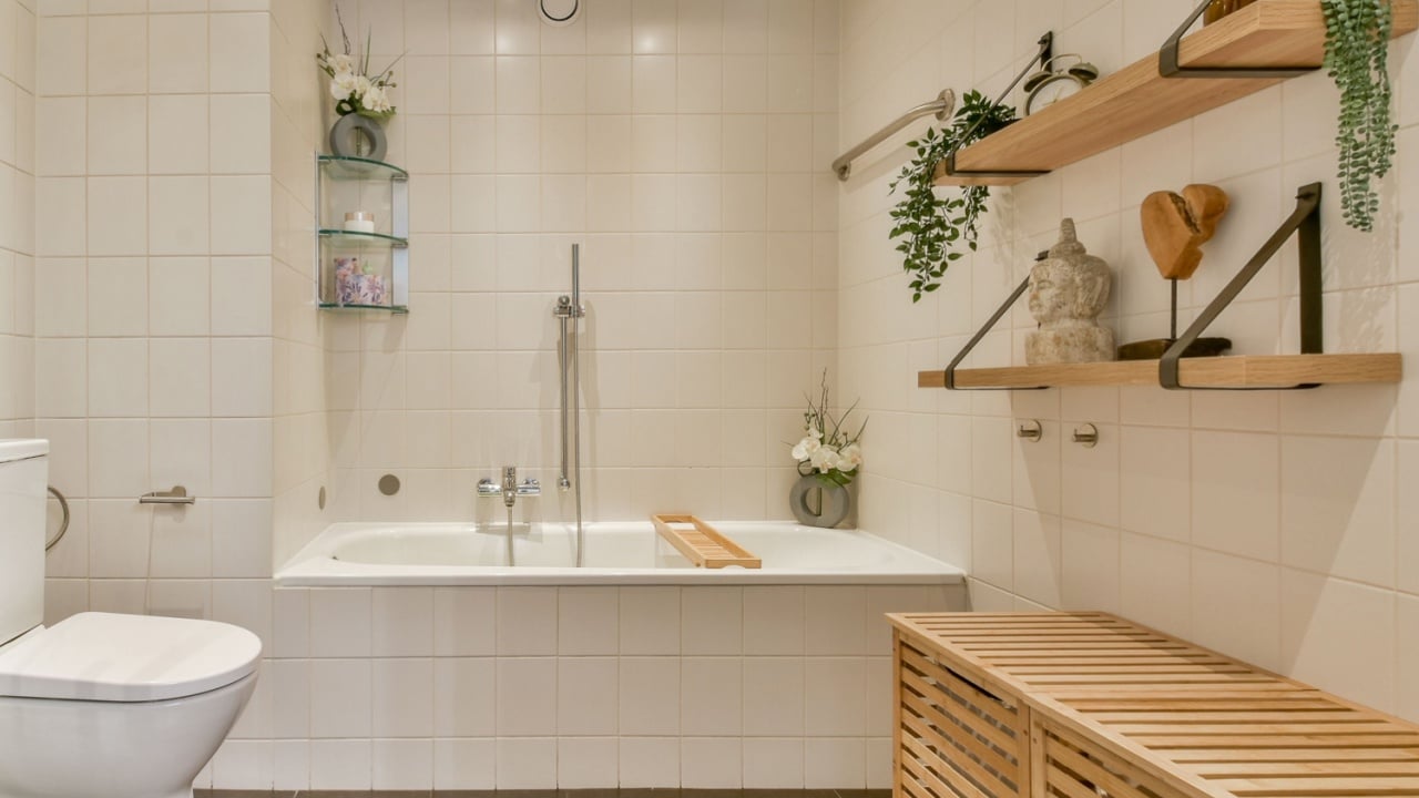 Featuring sleek lines and natural elements, this minimalist bathroom incorporates wood accents and plants for a serene atmosphere.
