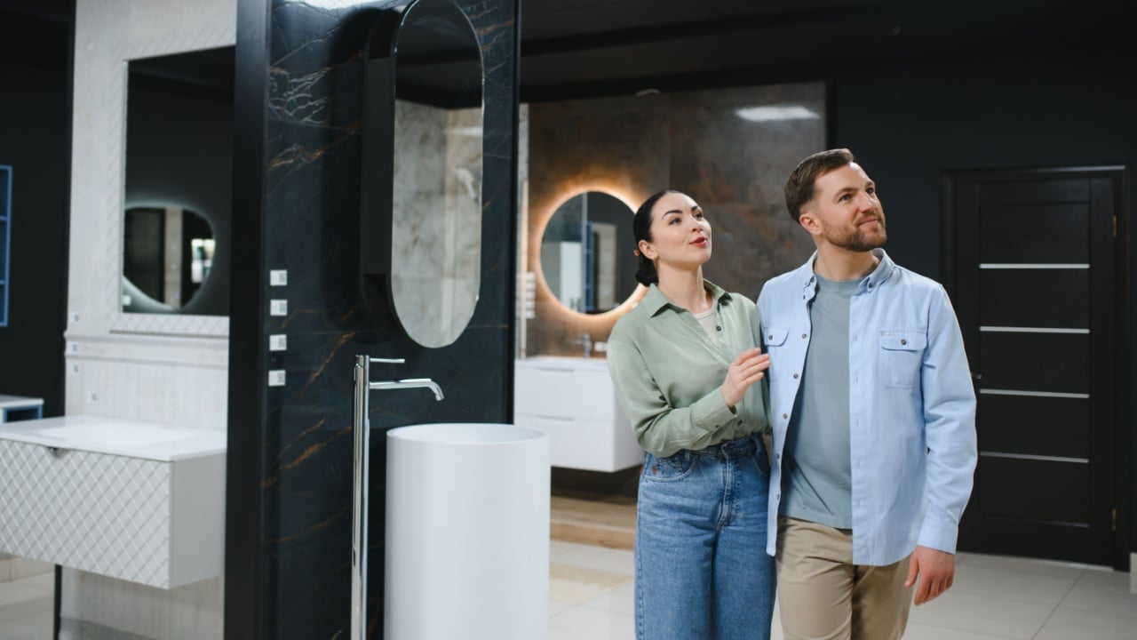 Couple walking in a bathroom fixtures store, choosing ceramic tiles and plumbing for their home renovation project