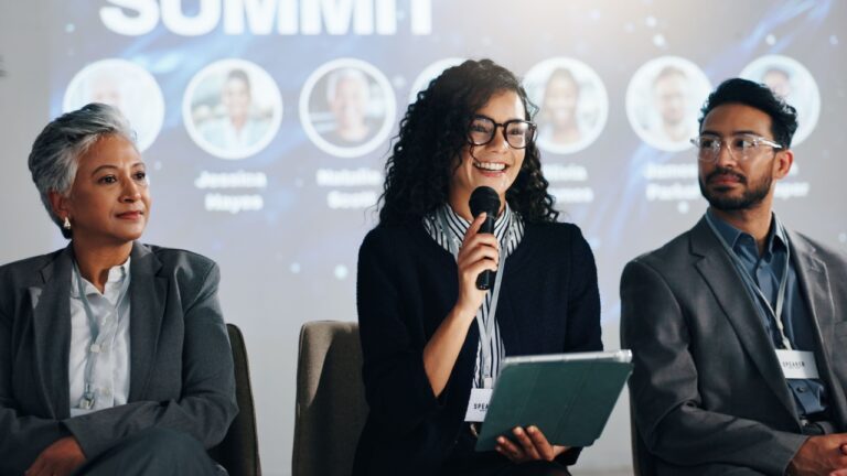 Stage, public speaking and woman with mic, tablet and smile for training session, group and seminar. Presentation, happy and speaker with motivation for entrepreneurship, people and tech for speech