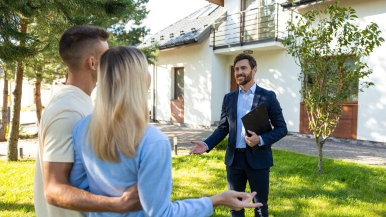 Real state agent giving the key from a new house to the clients