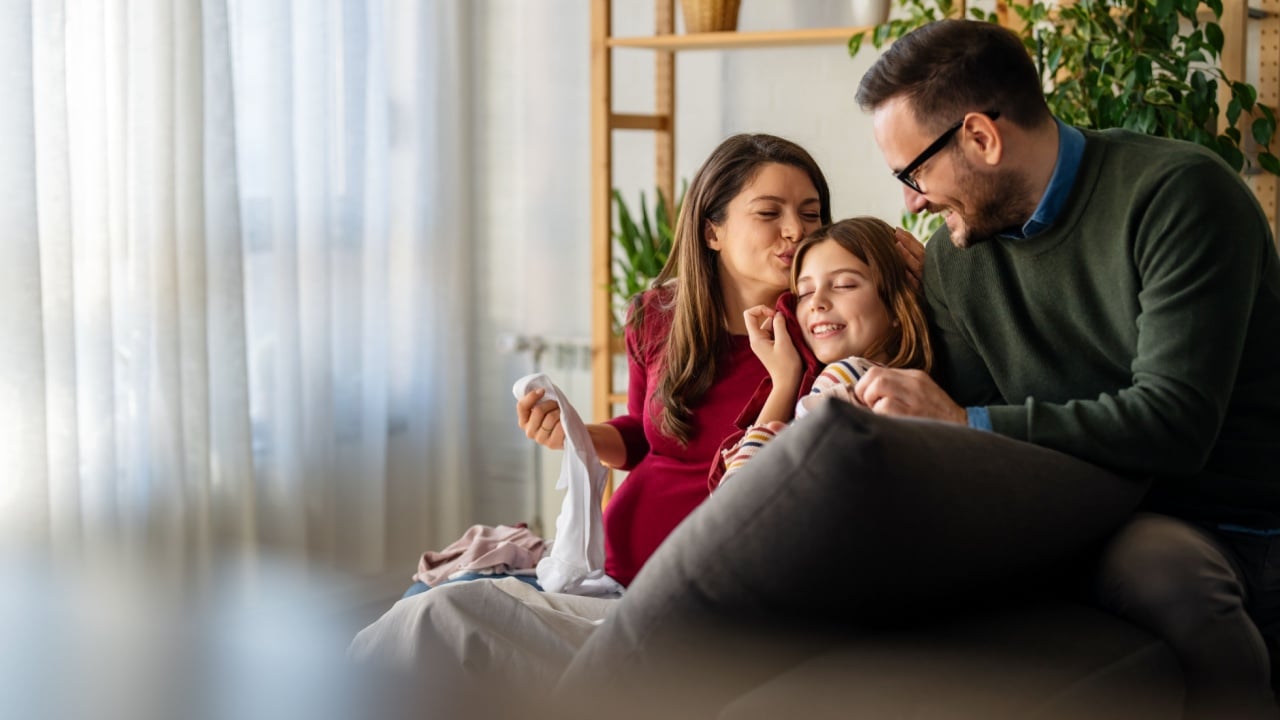 Happy parents, teen daughter having pleasant conversation, laughing chatting at home. Family weekend