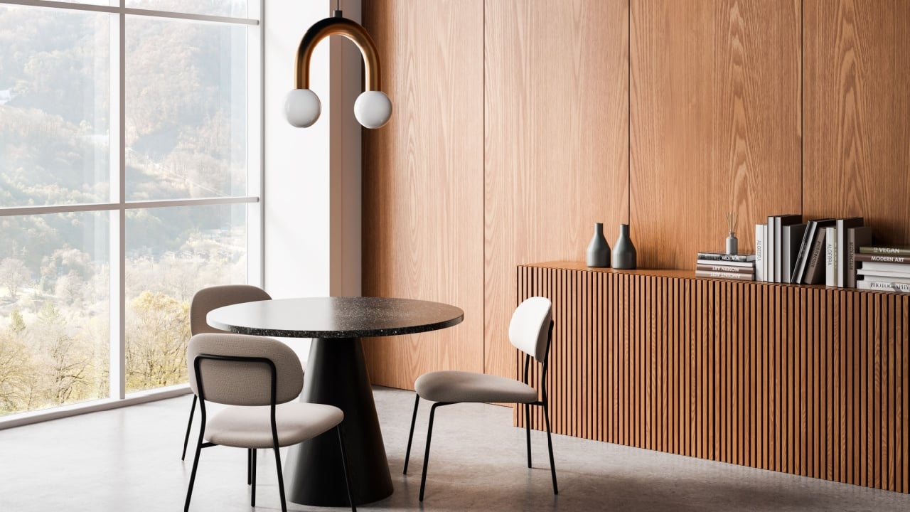 Modern interior dining space with wood panel wall, round table, neutral chairs, pendant light, and books on sideboard in natural daylight. 3D Rendering