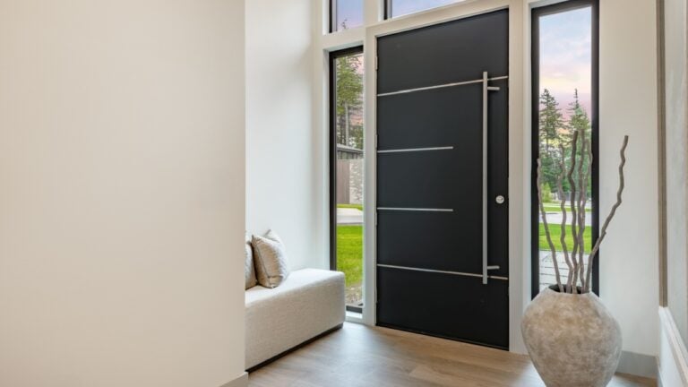 Modern black front door interior photograph of a foyer entry front door minimalist entryway high contrast design elements abundant natural light sleek black steel front door long vertical pull handle
