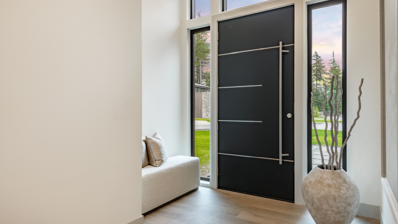 Modern black front door interior photograph of a foyer entry front door minimalist entryway high contrast design elements abundant natural light sleek black steel front door long vertical pull handle