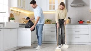Couple tidying up kitchen together. Domestic chores