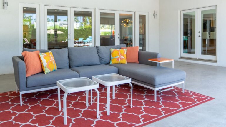 Outdoor patio sofa chaise lounge set with tables rug during daytime in Palm Springs, California
