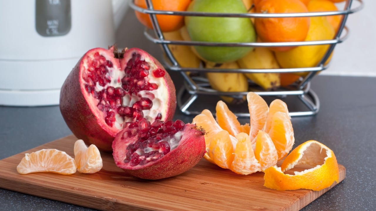 Peeled tangerine and cut pomegranate on the kitchen table