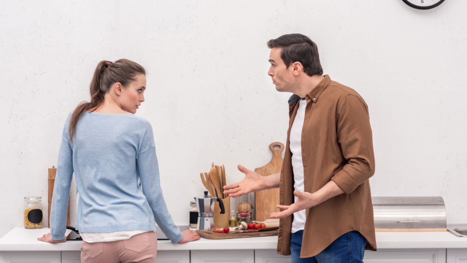Side view of adult couple having argument at kitchen