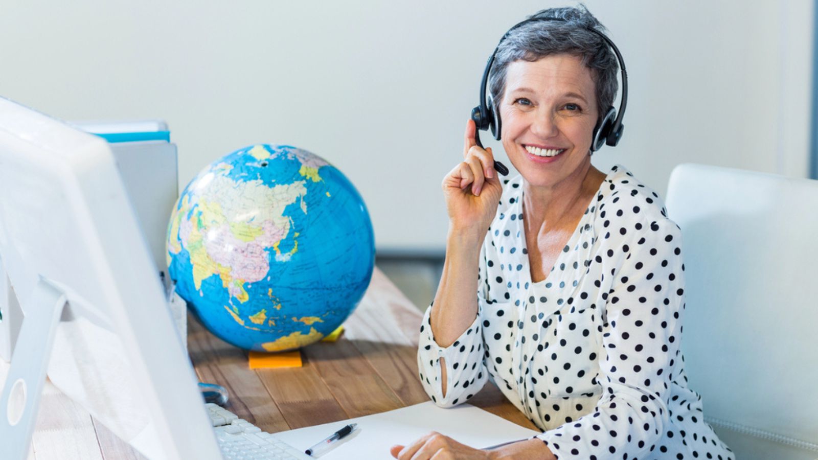 Smiling travel agent sitting at her desk