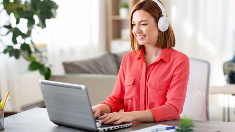 Woman in headphones with laptop working at home