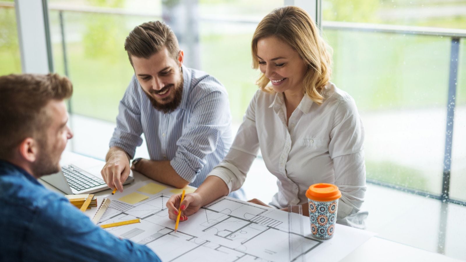 happy architect working in office with blueprints building home