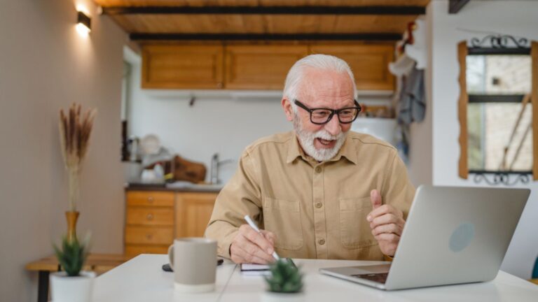 happy old senior retired man on laptop finances budgeting