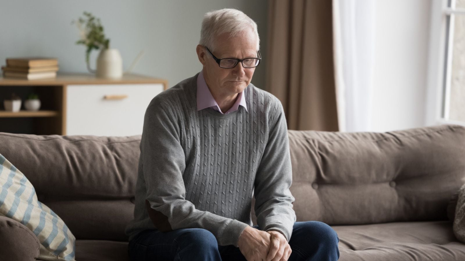 sad depressed elderly old retired man sitting alone on couch