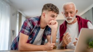 teenage grandchild child talking to dad grandfather grandpa studying tutoring confused