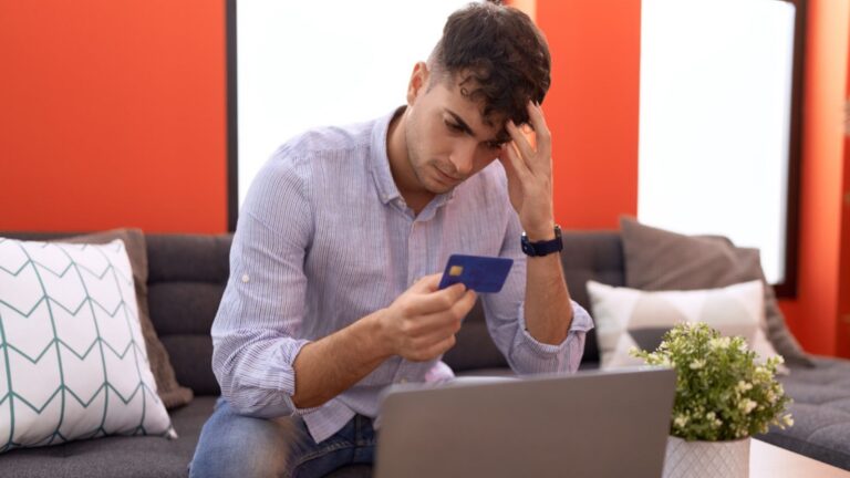 young man holding credit card no money stressed finances