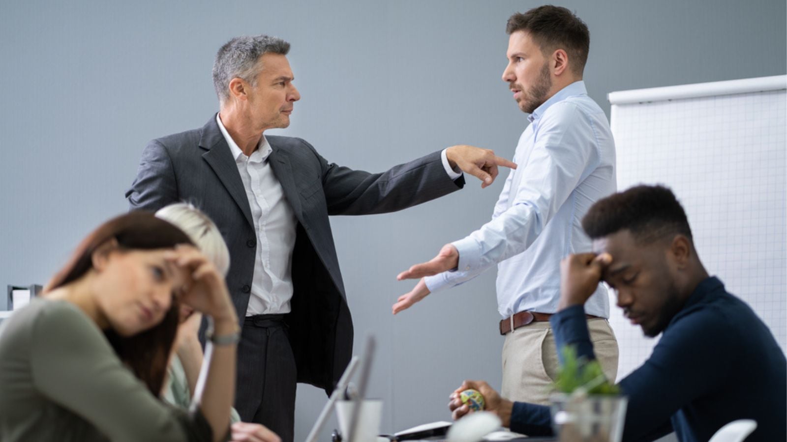 A colleague is angry on other and two are sitting and Sad office meeting