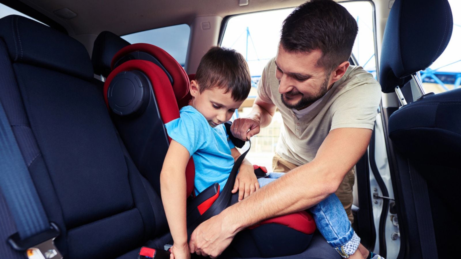 Concentrated father helps his son to fasten belt on car seat tiny baby foot with measles rash
