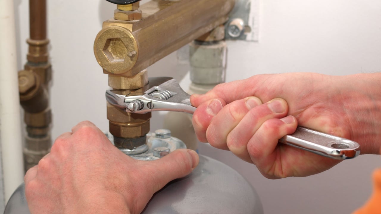 Men hands screwing valve with a spanner