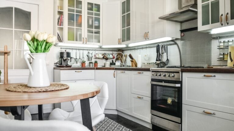 white Interior of the kitchen in Scandinavian style with white furniture and a dining table.