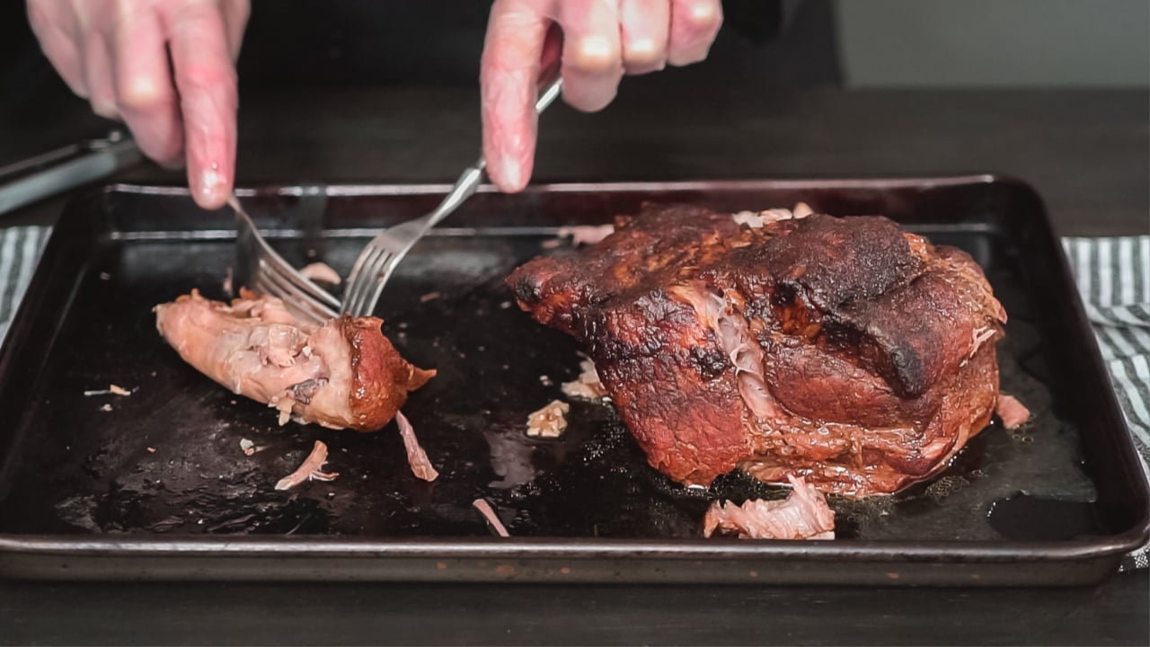 Step by step. Shredding pork roast shoulder with two forks.