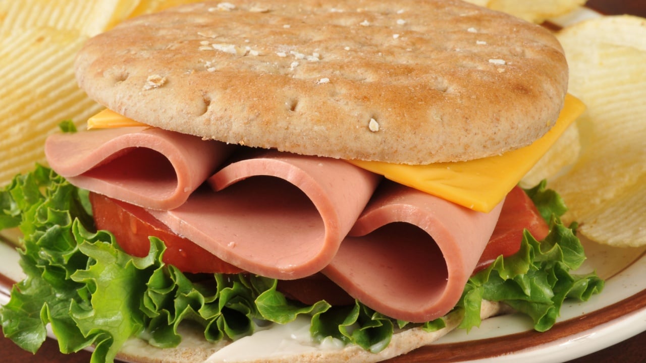 A bologna sandwich on thin round sandwich bread with potato chips