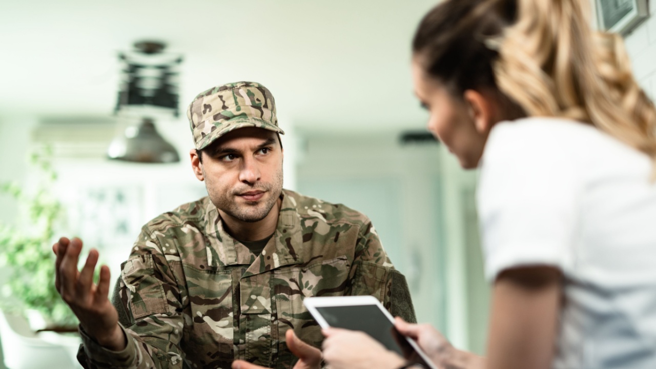 Young veteran talking to healthcare worker about his mental health condition at home. 