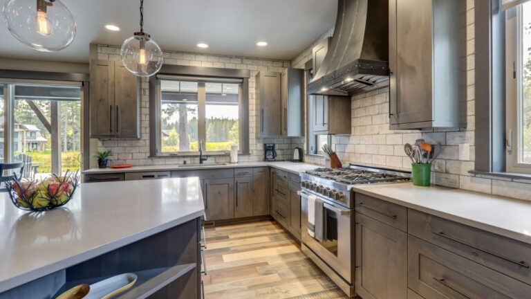Absolutly stunning kitchen interior with grey tone of brown muted natural tones with light hardwood and rustic modern island with colorful plates.