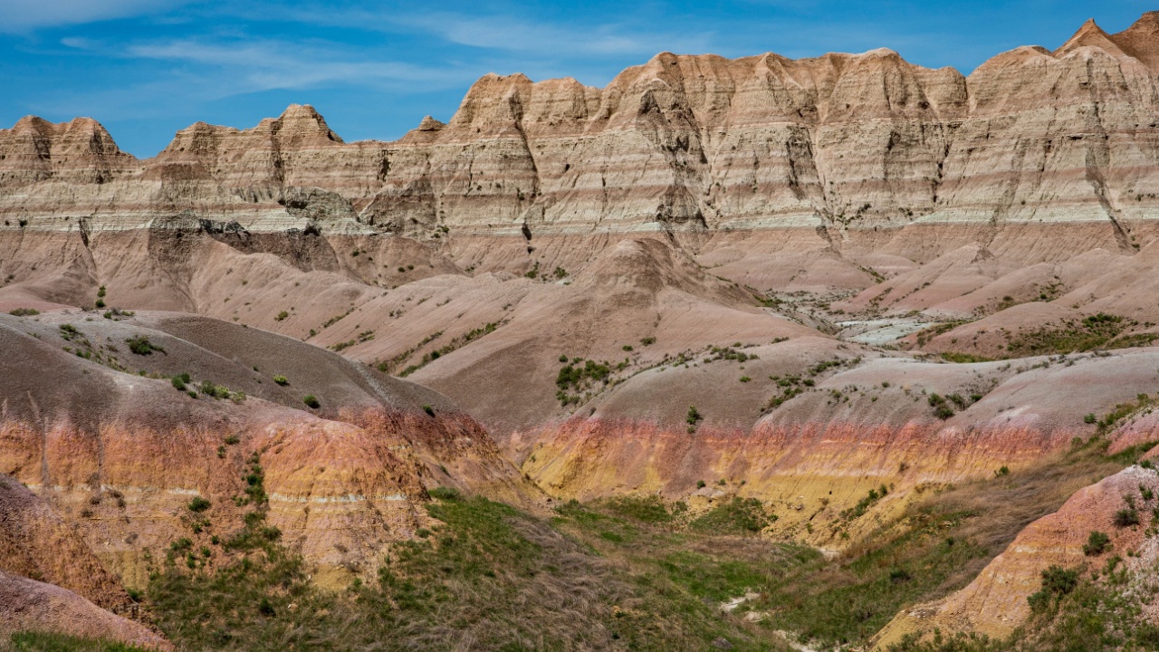 Reds, yellows, oranges and browns color the arid rocks, ridges and cliffs in the rugged Badlands of South Dakota.