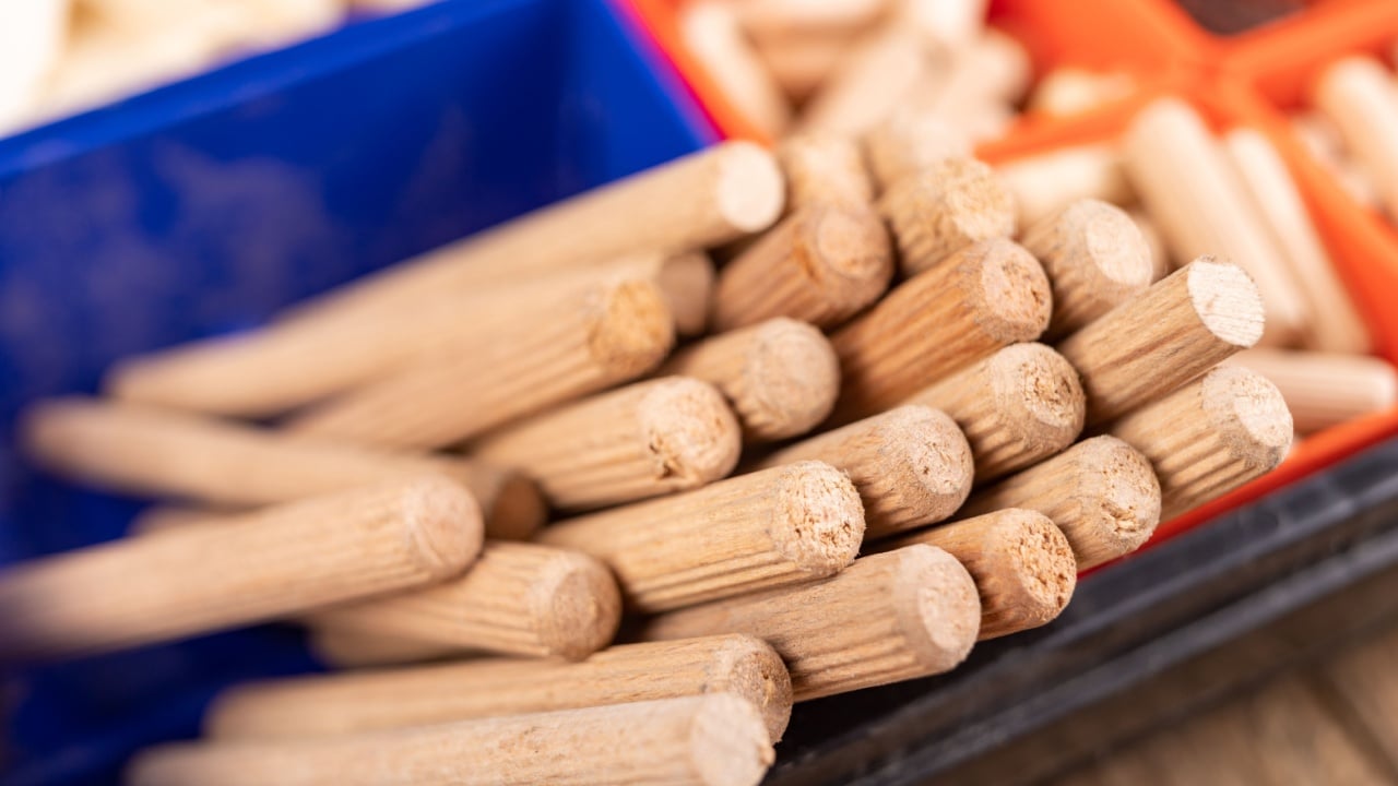 Wooden dowels used in carpentry. Utensils in a box for joining wood. Place - home workshop.