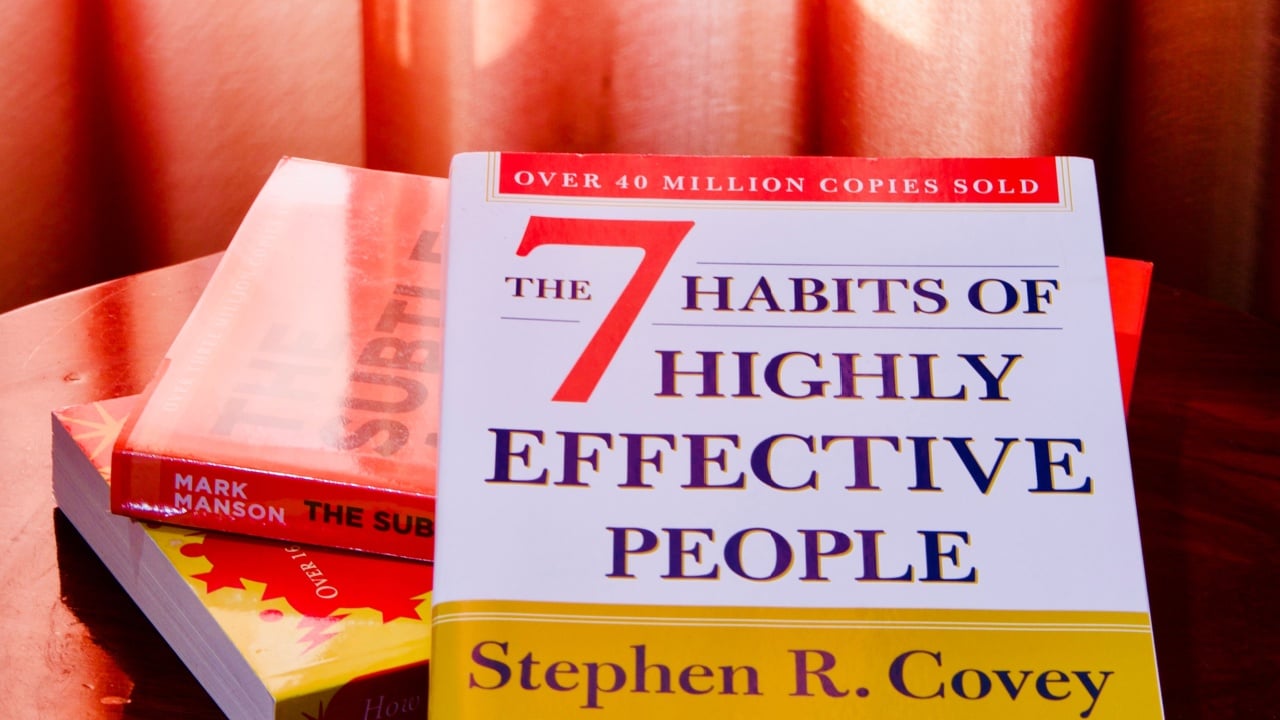 Thailand - Feb 19 2021: For illustrative editorial use only, the very famous book 7 Habits of Highly Effective People by Stephen R. Covey on other books, under natural light through red curtain.