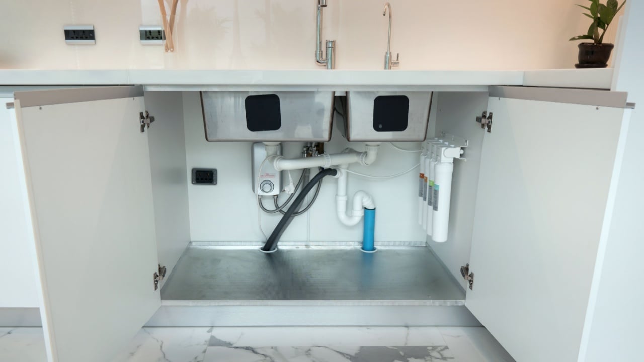 Open cabinet under sink 2 bowls with installed water pipe, water filter , Accessories aluminium under cabinet sink protection .White kitchen cabinet.