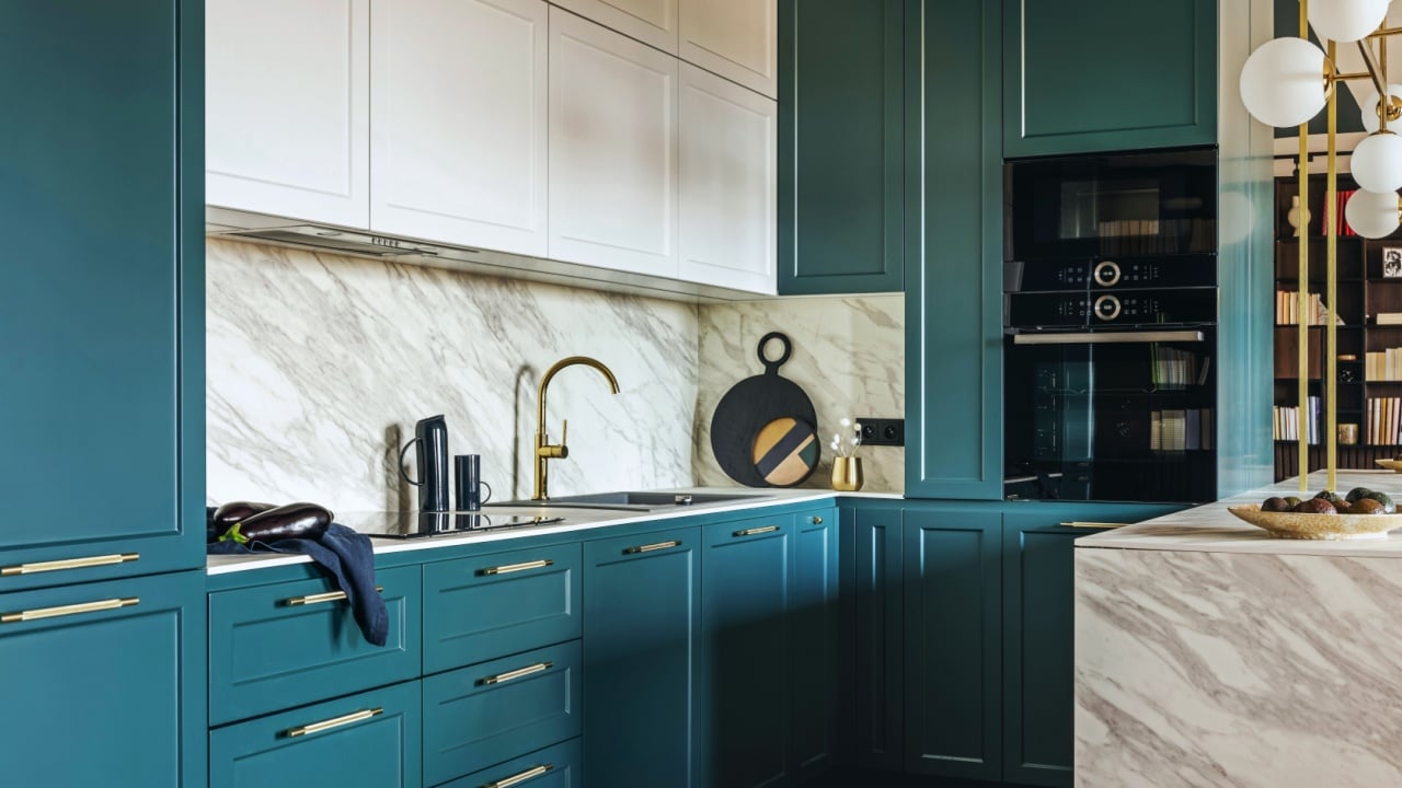 Luxury modern and vintage turquoise and white kitchen. Marble kitchen island with white owal chandelier . Gold tap on marble table top. 