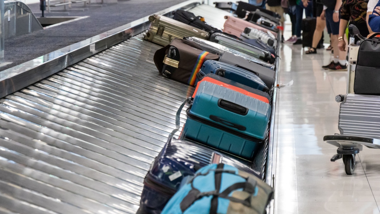 Baggage luggage at airport arrival carousel with passengers awaiting to claim theirs