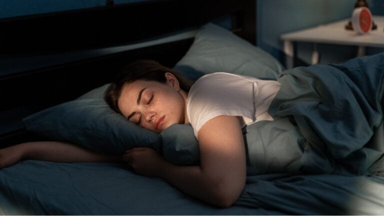 Young female sleeping peacefully in her bedroom at night. Relaxing at nighttime.