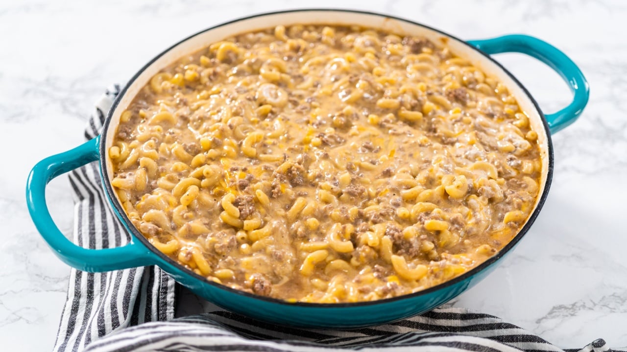 Cooking homemade hamburger helper in enameled cast iron skillet.