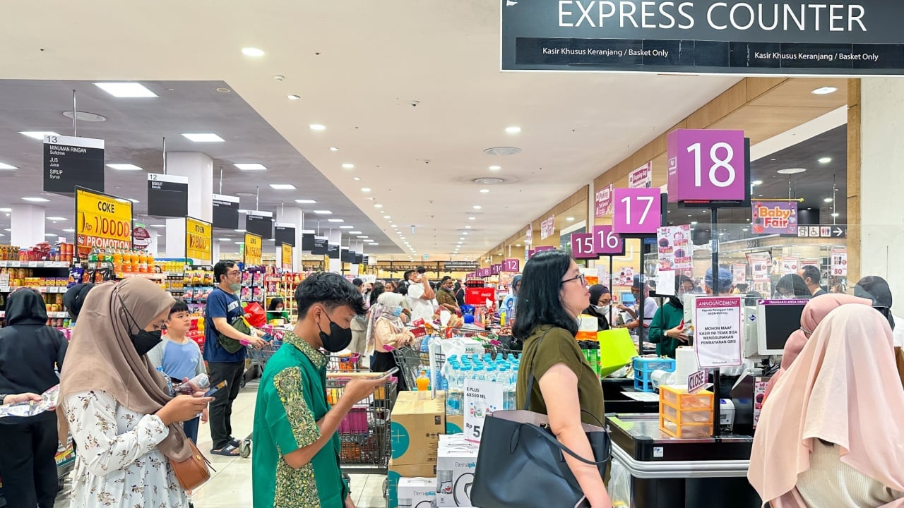 Jakarta, Indonesia - 2 June 2023: People waiting line at supermarket checkout counter doing payment transaction.