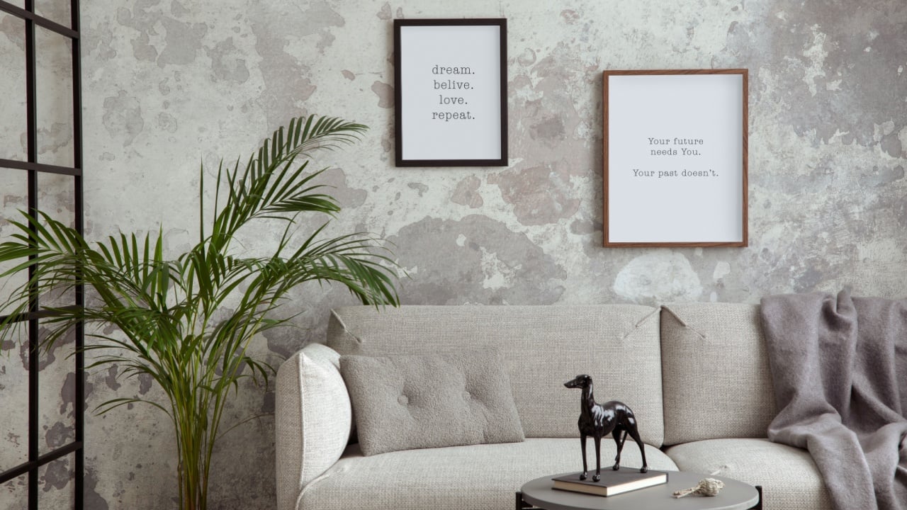 Sophisticated composition of modern living room with design sofa, coffee table, loft wall, mock up frame, decoration and personal accessories. Wabi sabi concrete wall. Minimalist home decor. Template.