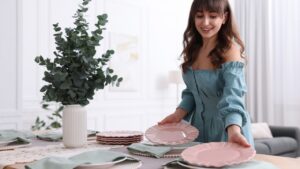 Woman setting table for dinner at home