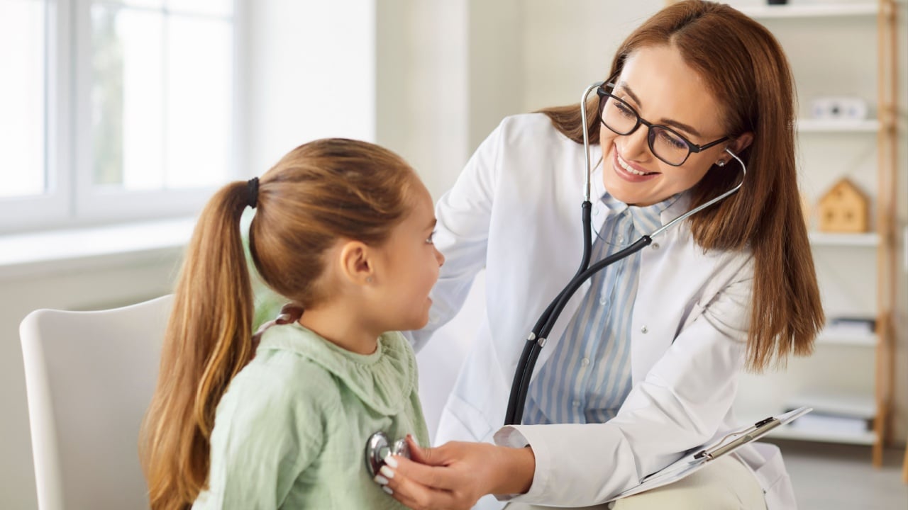 Pediatrician checking lungs, heart of small girl patient in clinic, female doctor, nurse holding stethoscope examining little child during regular pediatric checkup in hospital, medical health care
