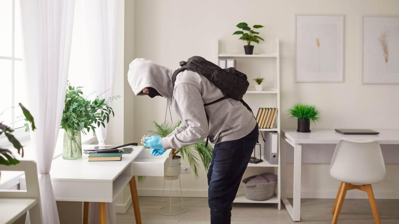 House intrusion, criminal offence male robber wearing hoodie, commits burglary, steals money or property from desk, active criminal, housebreaker, thief committing theft, illegally enters, breaking