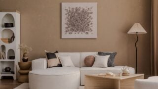 Minimalist interior with a curved sofa, pleated floor lamp, and modern wooden coffee table.
