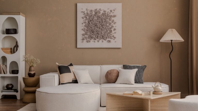 Minimalist interior with a curved sofa, pleated floor lamp, and modern wooden coffee table.