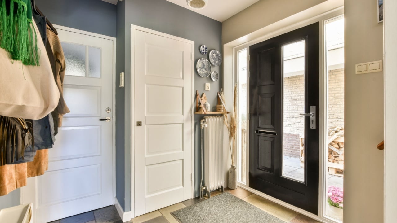 A stylish modern entryway featuring sleek doors, decorative elements, and a welcoming atmosphere. Perfect blend of functionality and aesthetics.